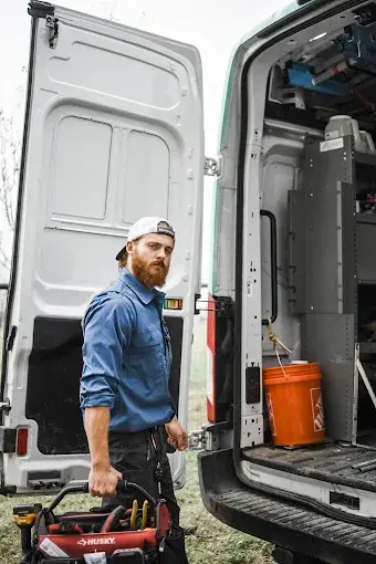 Clements Electric technician with a tool bag at the back of a service van